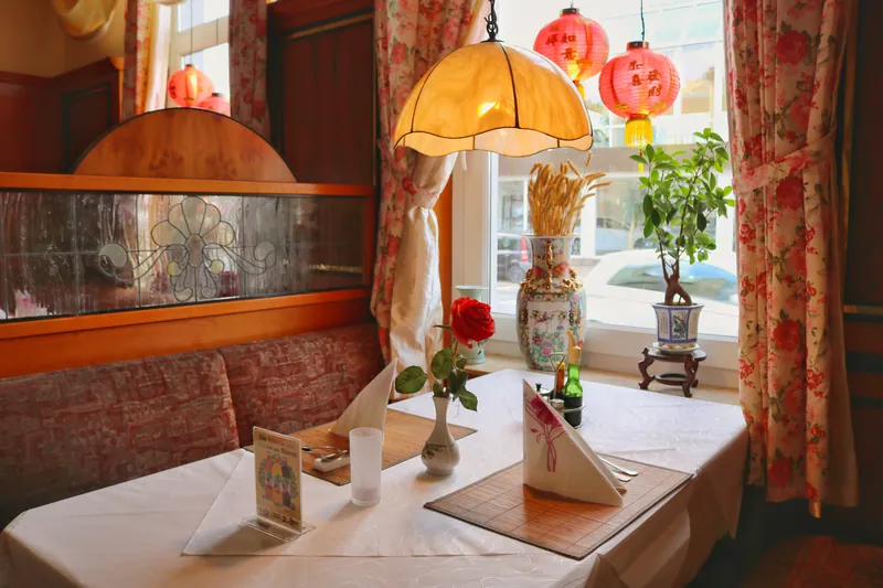 Tisch am Fenster mit Lampe und roten Laternen